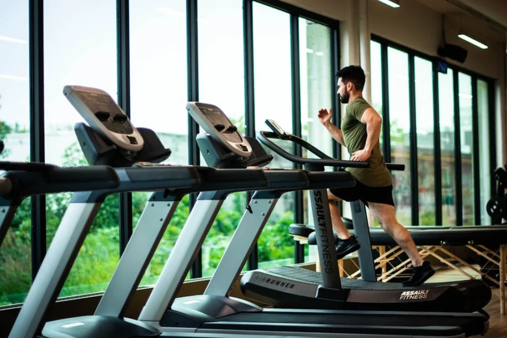 A man running on a treadmill at the gym.