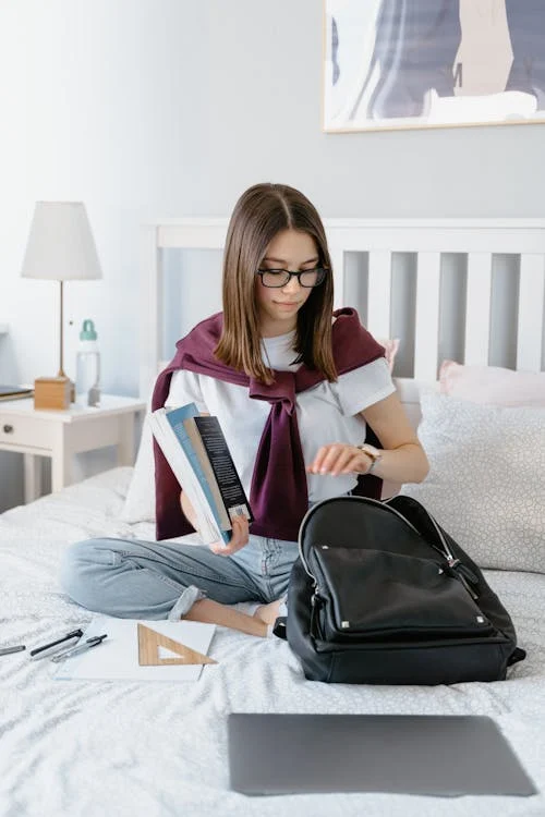 Student packing a laptop backpack with books and essentials