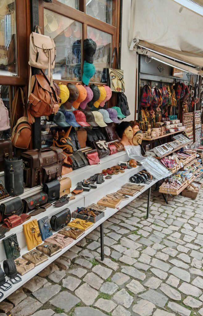 Market stall with various bags, hats, and accessories