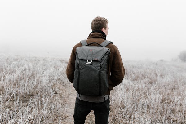 Rear view of a man with a backpack in a foggy outdoor setting