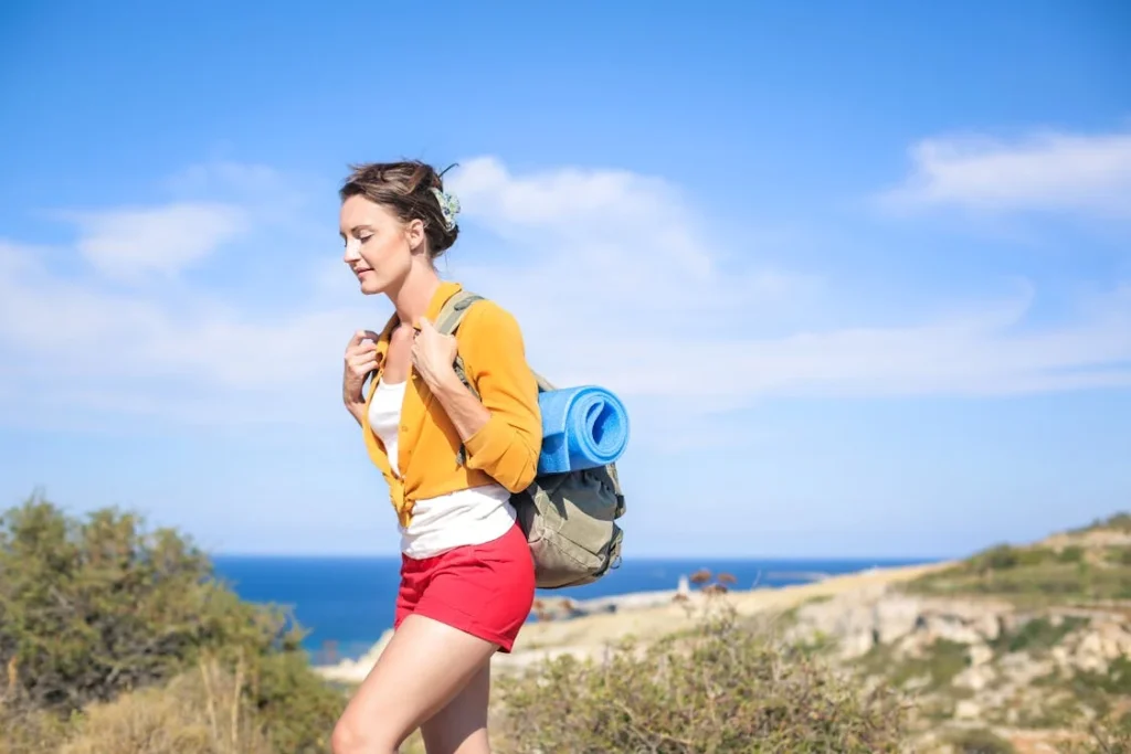 Hiker woman carries pack on coastal trail