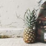 Pineapple meets camouflage backpack against textured wall